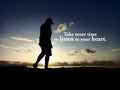 Inspirational and motivational quote - Take more time to listen to your heart. With silhouette of a woman walking alone on beach. Royalty Free Stock Photo