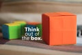 Inspirational  motivational quote - Think out of the box. With one big orange gift box and blur small colorful cubes background. Royalty Free Stock Photo