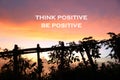 Inspirational motivational quote- think positive, be positive. On colorful romatic sunset background and wooden fence silhouette. Royalty Free Stock Photo