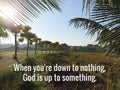 Inspirational motivational quote - When you\'re down to nothing, God is up to something. With palm tree and bright sky. Royalty Free Stock Photo