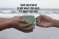 Inspirational motivational quote - Your greatness is not what you have. It is what you give. With hands holding coffee cup.