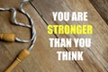 Inspirational motivational quotes You Are Stronger Than You Think on wooden background. Health and fitness concept.