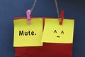 Inspirational note quote - Mute. With mute face emoticon on colorful origami paper hanging on wall with pin and rope.