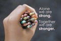 Inspirational quote - Alone we are strong. Together we are stronger. With Bunch of colored pencils in hand Royalty Free Stock Photo