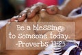 Inspirational quote - Be a blessing to someone today. Proverbs 11.25. On background of women holding hands on lap.