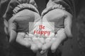 Inspirational quote - Be happy in an open hand in black and white background. Happiness and words of wisdom concept. Royalty Free Stock Photo