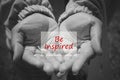 Inspirational quote - Be inspired in an open hand in black and white background. Self improvement and words of wisdom concept Royalty Free Stock Photo