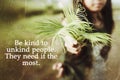 Inspirational quote - Be kind to unkind people. They need it the most. With young woman holding fern plant or palm leaves in hand. Royalty Free Stock Photo