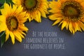 Inspirational quote - Be the reason someone believe in the goodness of people. With three sunflowers on gray background. Kindness.