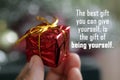 Inspirational quote - The best gift you can give yourself, is the gift of being yourself. Person holding red small box in hand