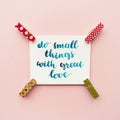 Inspirational quote do small things with great love handwritten with watercolor in calligraphy style, miniature clothespins