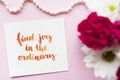 Inspirational quote Find joy in the ordinary written in calligraphy style with watercolor. Composition on a pink background. Flat