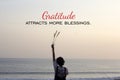 Inspirational quote - Gratitude attracts more blessings. With young woman standing alone in the beach, watching sunset over ocean. Royalty Free Stock Photo