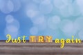 Inspirational quote - Just try again. Motivational words with wooden block concept on vintage soft blue bokeh background