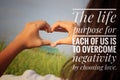 Inspirational quote - The life purpose for each of us is to overcome negativity by choosing love. With girl making hands love sign Royalty Free Stock Photo