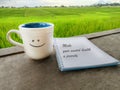 Inspirational quote - Make your mental health a priority. Physiology text message on spiral notebook with smiling cup of tea. Royalty Free Stock Photo