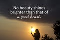 Inspirational quote - No beauty shines brighter than that of a good heart. With silhouette of a young woman holding grass flower.
