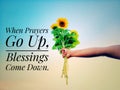 Inspirational quote - When prayers go up, blessings come down.  With hand holding bouquet of sunflowers against bright blue sky. Royalty Free Stock Photo
