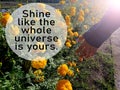 Inspirational quote - Shine like the whole universe is yours. With hand touched by the sun light over marigold flowers garden.