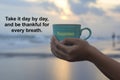 Inspirational quote - Take it day by day, and thankful for every breath. With person holding a cup of coffee in hands. Royalty Free Stock Photo