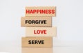Inspirational single kind word on wooden blocks about happiness, forgive, love and serve