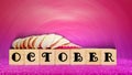 inspirational time concept - word october on wooden blocks with seashells in purple vintage background
