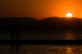 Inspirational tropical beach landscape. Orange and golden sunset sky with couple silhouette, calmness, relaxing sunlight, summer