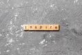 Inspire word written on wood block. Inspire text on cement table for your desing, concept