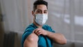 Inspired arabian hispanic man young male practitioner nurse intern in medical face mask showing injection mark adhesive