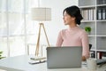 An inspired Asian businesswoman is looking out the window, daydreaming Royalty Free Stock Photo