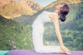 Inspired asian woman doing exercise of yoga at mountain range