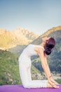 Inspired asian woman doing exercise of yoga at mountain range