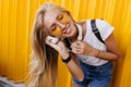 Inspired fair-haired girl in jeans listening music with eyes closed. Slim tanned female model in sun Royalty Free Stock Photo