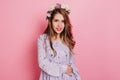 Inspired female model wears purple attire looking to camera. Elegant white girl with beautiful flowers in long hair Royalty Free Stock Photo