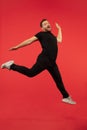 Full length portrait of young successfull high jumping man gesturing isolated on red studio background Royalty Free Stock Photo