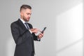 Inspired handsome businessman in formal wear standing holding sm