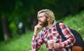 Inspired handsome hipster. Drink tea or coffee. Man with cup outdoors. Enjoying nature at riverside. Guy with backpack Royalty Free Stock Photo