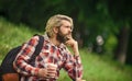 Inspired handsome hipster. Drink tea or coffee. Man with cup outdoors. Enjoying nature at riverside. Guy with backpack Royalty Free Stock Photo