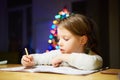 Inspired little girl at the table draw with crayons or do home work Royalty Free Stock Photo