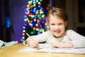 Inspired little girl at the table draw with crayons or do home work Royalty Free Stock Photo