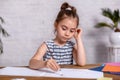 Inspired little girl at the table draw with paints