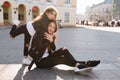 Inspired little girl in trendy jeans with holes embracing mother, standing on one leg. Amazed young woman with long legs Royalty Free Stock Photo