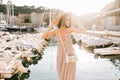 Inspired shapely girl wearing hat and little bag posing with smile in front of river in sunny day. Beautiful young woman Royalty Free Stock Photo