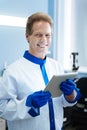 Inspired smiling scientist holding a tablet