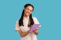 Inspired woman smiling and writing down interesting idea in notebook, making plans, to-do list. Royalty Free Stock Photo