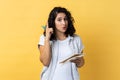 Inspired woman writing in paper notebook, having new excellent idea, raising finger up.