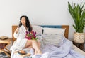 Inspired young asian woman enjoying romantic breakfast in bed, happy life, relaxation Royalty Free Stock Photo