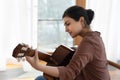 Inspired young indian female guitarist hold guitar play lyrical melody