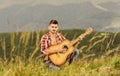 Inspiring environment. Man with guitar on top of mountain. Acoustic music. Summer music festival outdoors. Playing music Royalty Free Stock Photo