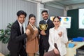 An inspiring image of a diverse cadre of business professionals, beaming with pride, as they pose with a coveted trophy in a